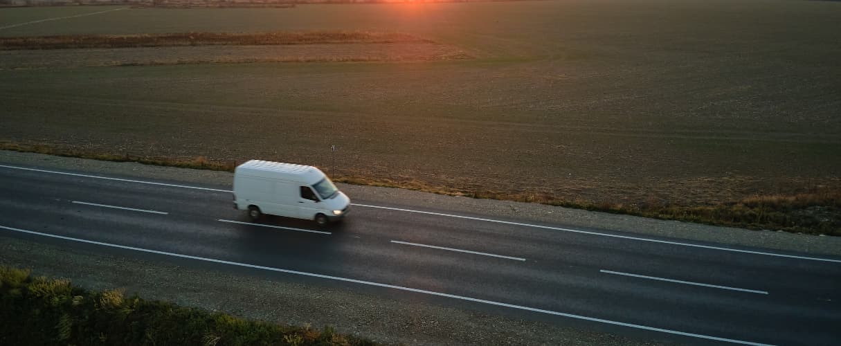 aerial van of white van driving down dual carriageway