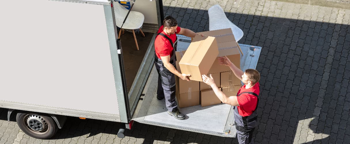 Professional removals team loading cardboard boxes into a moving lorry during a house or office relocation service